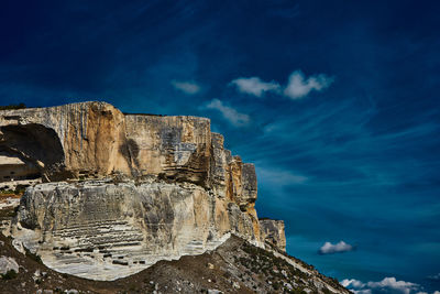 Low angle view of rock formation against sky