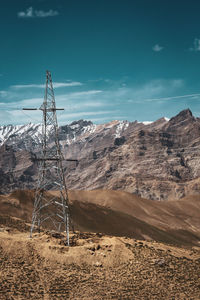 Electricity pylon on land against sky