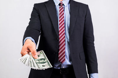 Midsection of businessman standing against white background