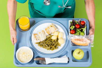 Midsection of doctor holding food in tray