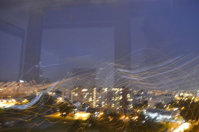 Illuminated city against sky at night