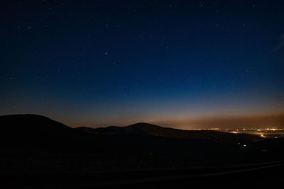 Scenic view of silhouette mountains against sky at night