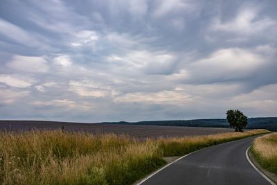 Empty road along countryside landscape