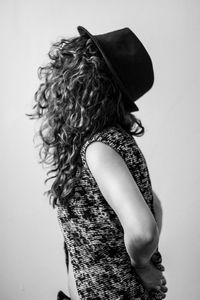 Midsection of young woman standing against white background