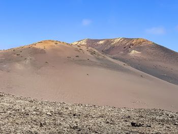 Scenic view of desert against clear blue sky