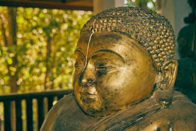 Close-up of buddha statue against building