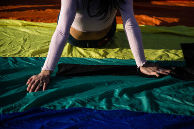 Midsection of woman sitting on rainbow flag