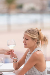 Close-up of woman holding drink in water