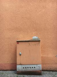 Abandoned mailbox on street by wall