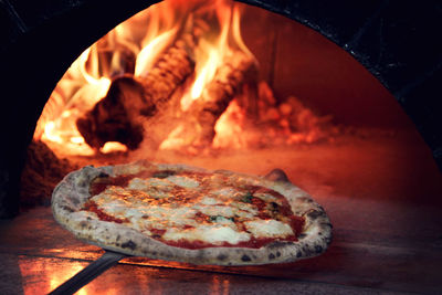 Close-up of pizza being put in oven