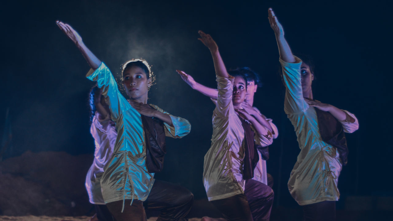 GROUP OF PEOPLE DANCING IN MID-AIR