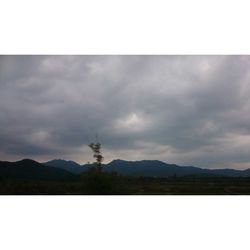 Scenic view of mountains against cloudy sky