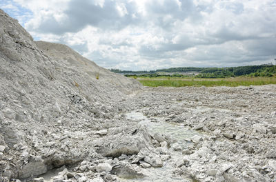 Scenic view of chalk landscape at rugen against cloudy sky