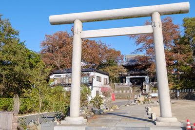 Built structure and trees by building against blue sky