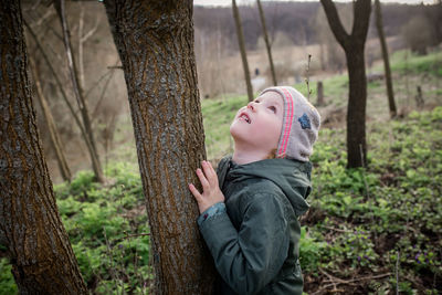 Portrait of young woman looking away while standing in forest