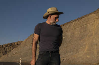 Adult man in cowboy on desert against mountain. almeria, spain