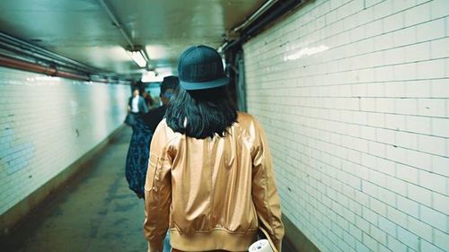 Rear view of people walking in tunnel