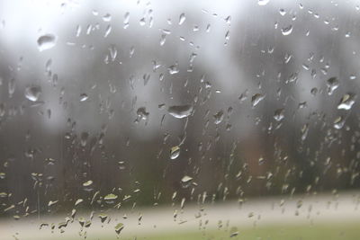 Close-up of wet glass window during rainy season