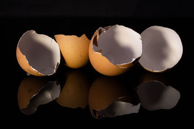 Close-up of broken egg against black background