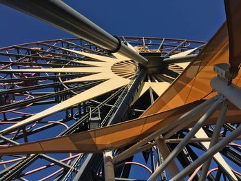 Low angle view of ferris wheel against clear blue sky