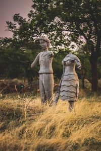 Statue on field against trees