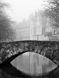 Bridge over river against sky during winter