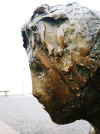 Close-up of old statue against water