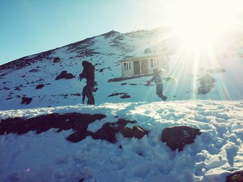 Rear view of people skiing on snow covered landscape