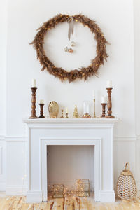 White fireplace decorated with a wreath for the holidays in a cozy home