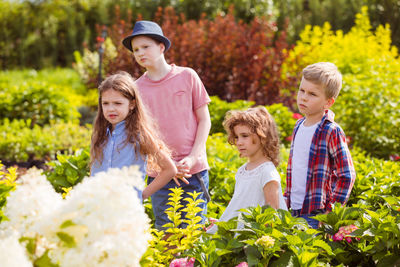 Full length of friends looking at plants