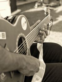 Midsection of man playing guitar