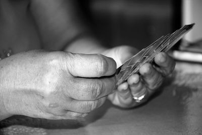 Cropped image of person playing cards