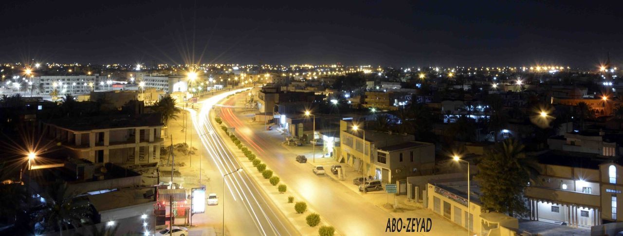 illuminated, night, city, building exterior, cityscape, architecture, high angle view, built structure, residential district, city life, residential building, road, street, residential structure, transportation, crowded, street light, sky, lighting equipment, light trail