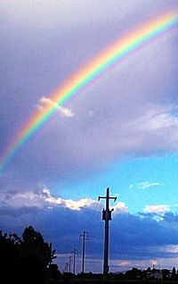 Low angle view of rainbow against cloudy sky