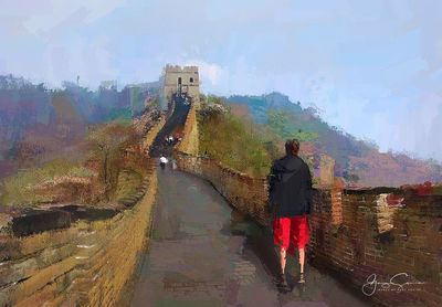 People on wet road against sky during rainy season