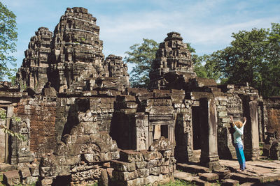 Side view of mid adult woman standing outside ankor wat temple