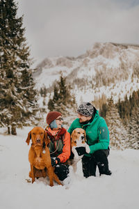 Couple in love and dogs playing in the snow