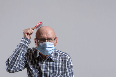 Portrait of man wearing mask against gray background