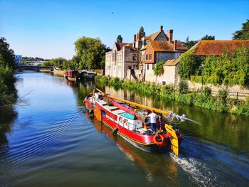 Graffiti on river by building against sky