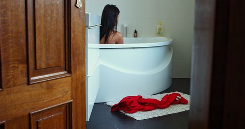 Midsection of woman in bathroom at home
