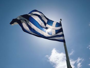 Low angle view of flag against blue sky