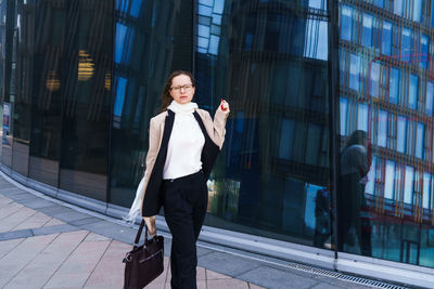Successful happy business woman with bag over office building background person