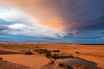 Scenic view of desert against sky during sunset