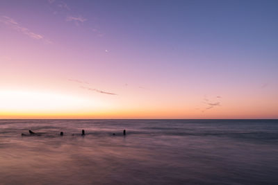 Scenic view of sea against clear sky at sunset