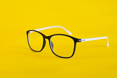 Close-up of sunglasses against yellow background