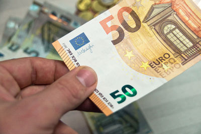 Close-up of hand holding paper with text