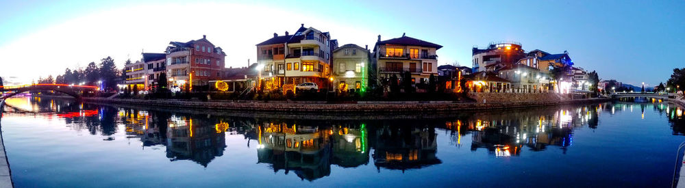 Reflection of buildings in city at waterfront