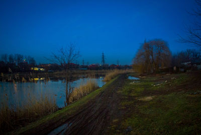 Scenic view of lake against clear blue sky at night