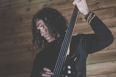 Mature man playing musical instrument at home