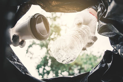 Cropped hand throwing garbage in bin